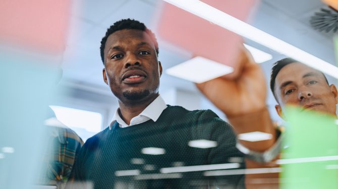 African american young businessman writing his ideas on a sticky notes