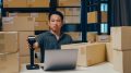 Asian businessman use barcode machine scan customer data in paper box and type register online.