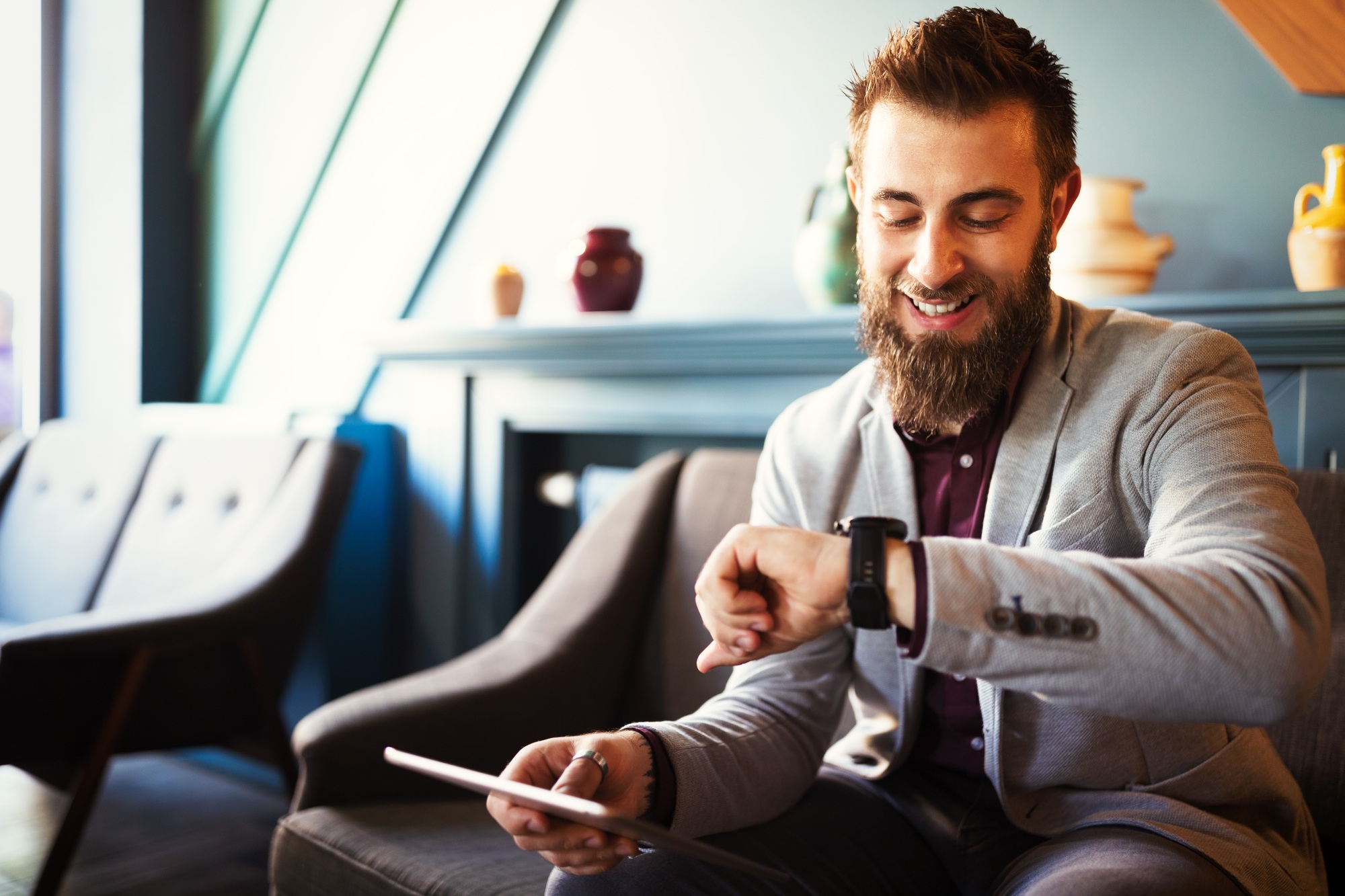 Business and time management concept. Happy business man looking at wrist watch