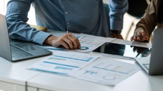 businessman and partnership pointing the graph to analyze the marketing plan with calculater and