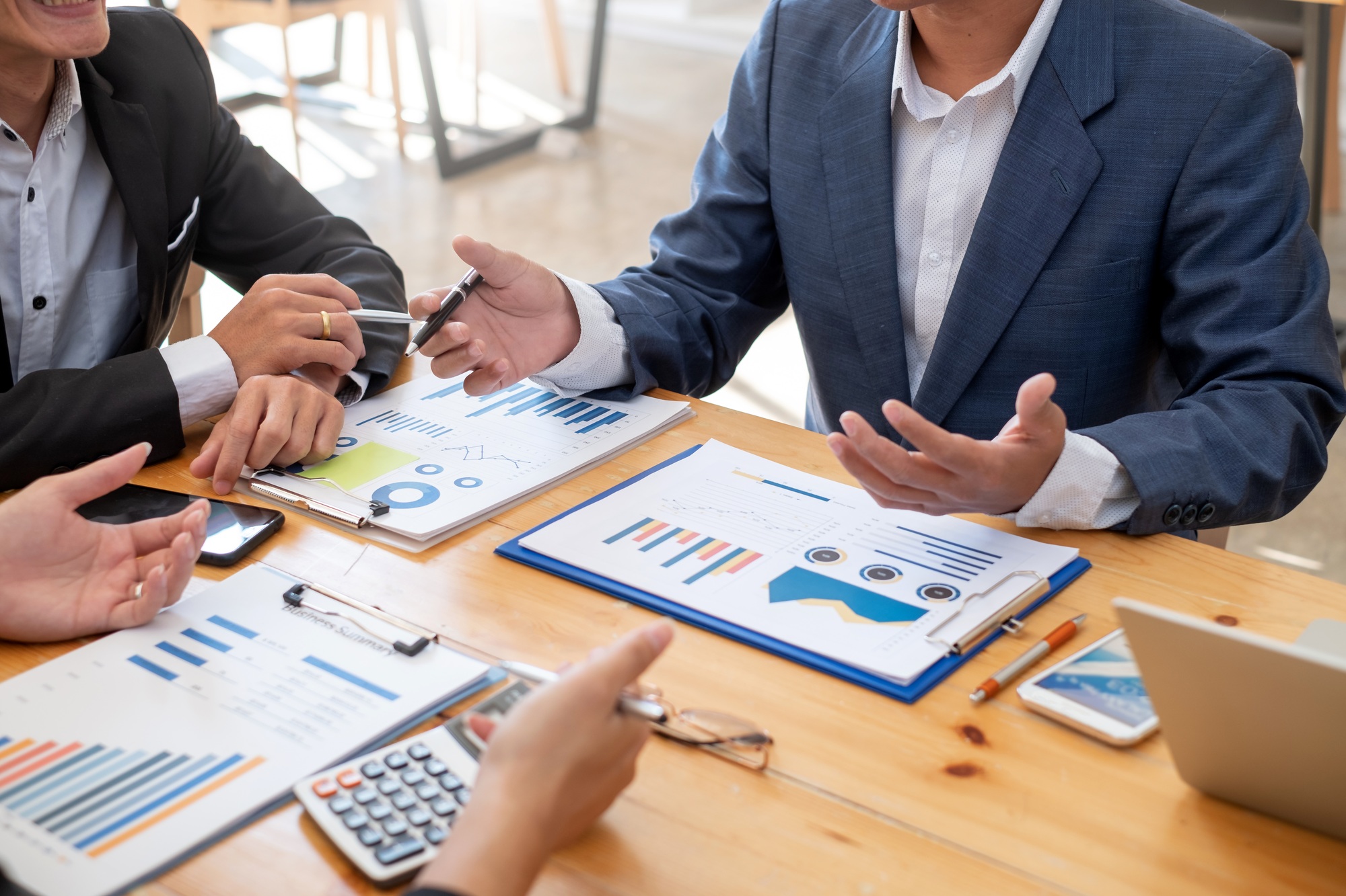 Businessmen view financial graph data to plan market investment.