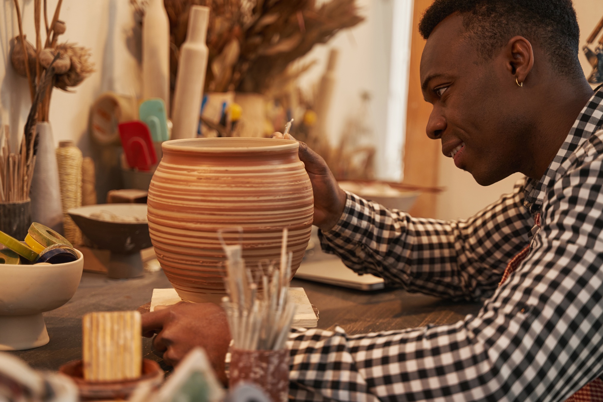 Cheerful potter crafting new piece of pottery