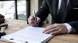 Close-up, lawyers are writing names, signing documents, contracts, legal agreements.