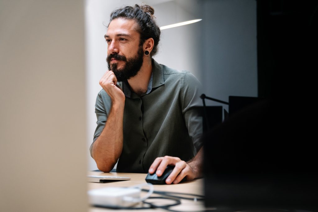 Concentrated young business man employee worker analyzing online sales statistics data on computer