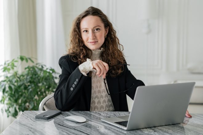 Confident female professional eating lunch at her desk, work-life balance theme.