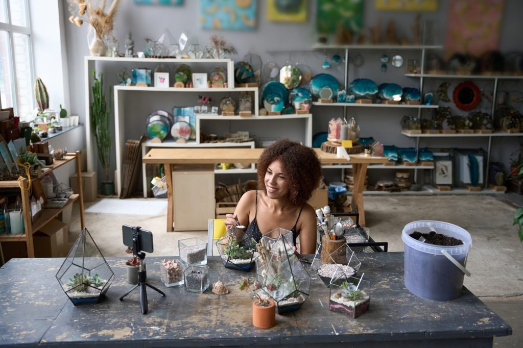 Creative female florist making a tutorial video about florariums