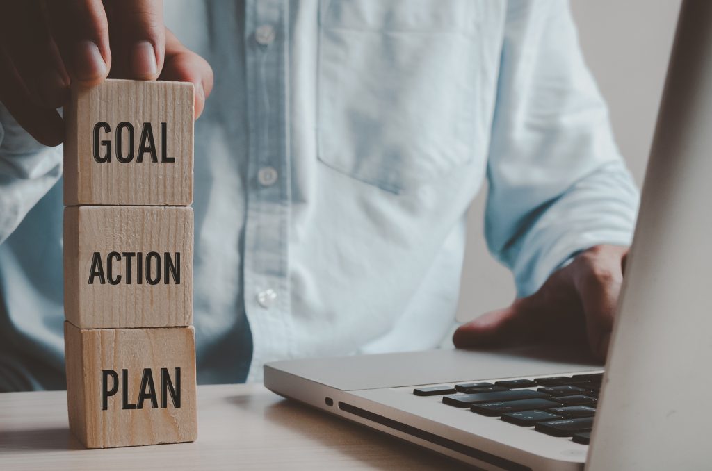 Hands holding cubes Plan and Action for Success Goals with text concept business