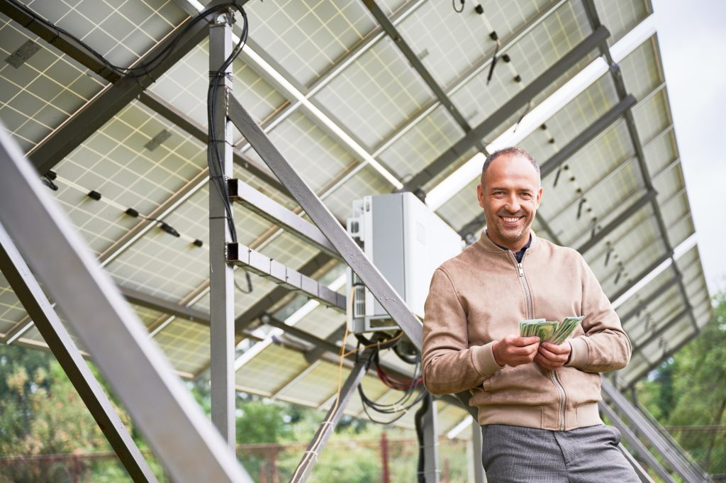 Happy man smiling because of profit he got after investing in alternative innovations.
