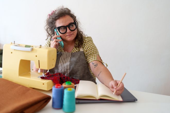 Home based seamstress multitasking, handling textile orders via phone