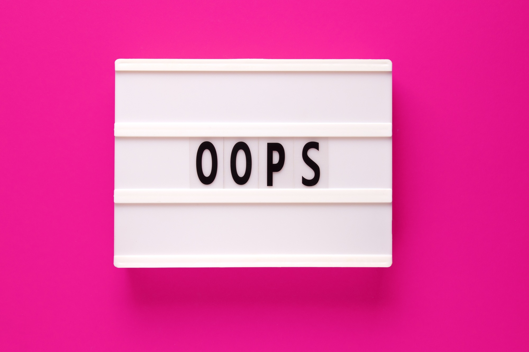 Lightbox with word oops on pink background. Apologies for a a mistake or error.