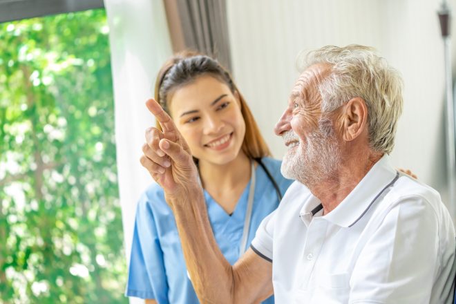 Man being cared for by a private Asian nurse at home