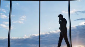 Mature businessman with smartphone in a hotel.