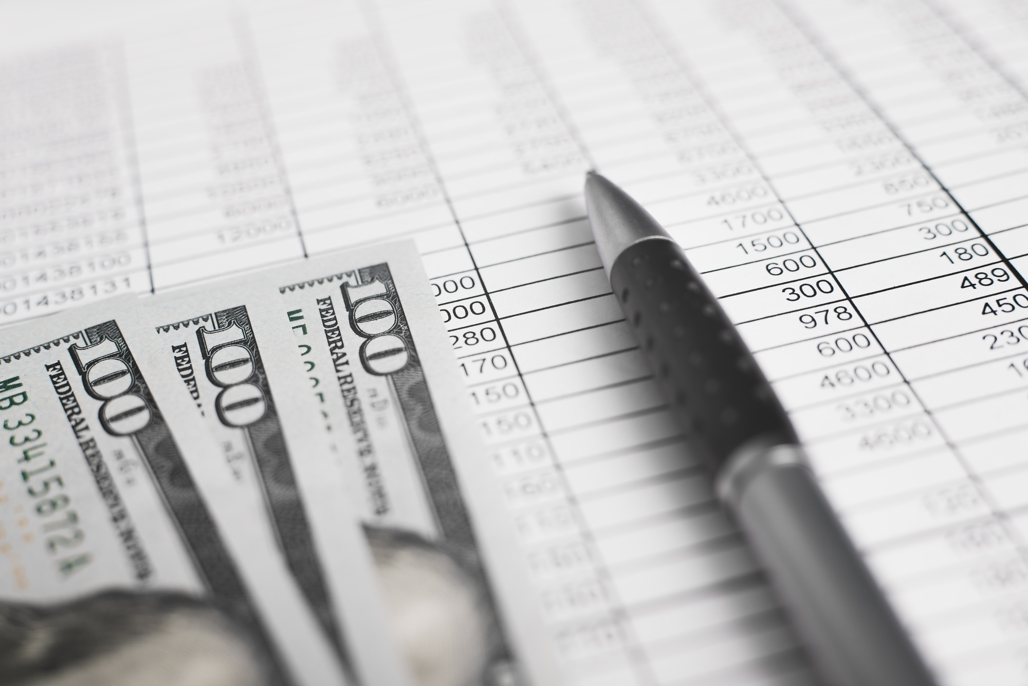 Money, accounting documents invoices and a pen. Close-up, low angle view, selective focus