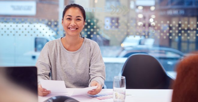 Portrait Of Smiling Asian Businesswoman Sitting At Table In Office  Meeting Room