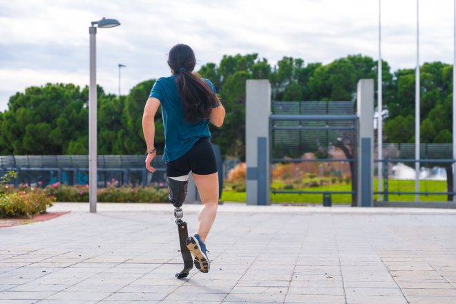 Rear view of a handicapped runner in a park