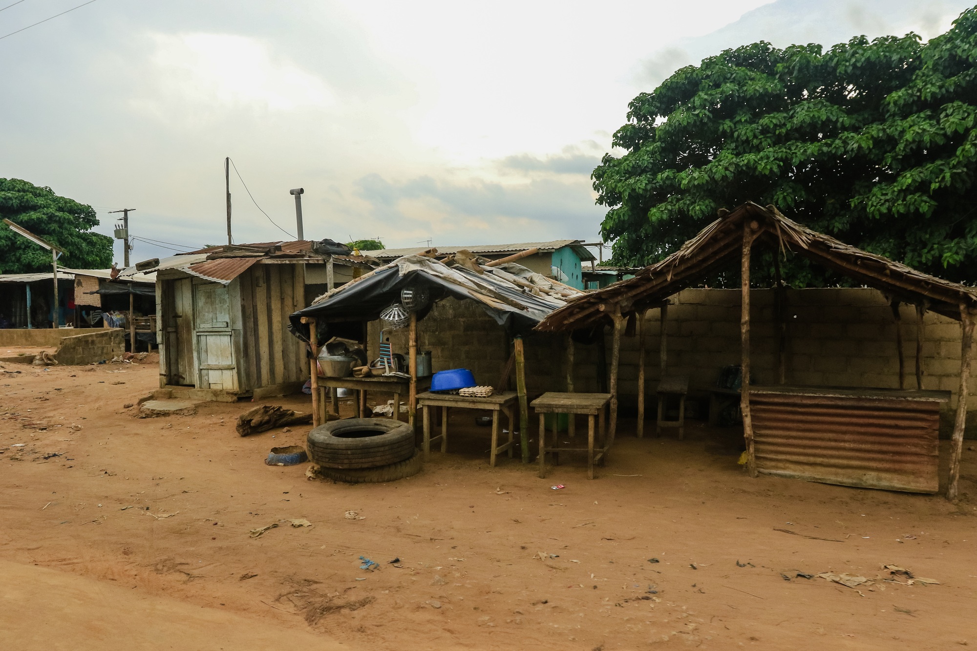 Rural marketplace in Ivory Coast with makeshift stalls and natural surroundings