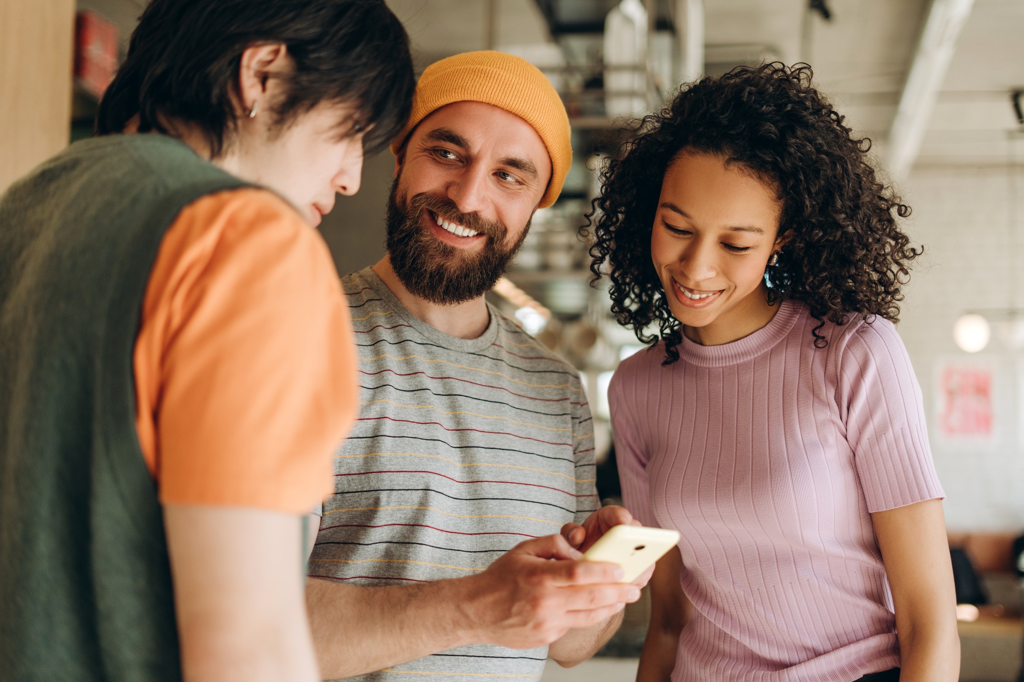 Startup team sharing ideas and using smartphone in coworking space