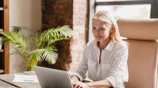 Tutor teacher working typing on laptop, searching information, social media surfing online in office