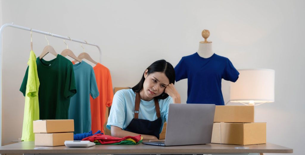 Woman seller SME retail store owner work hard worry stress in bad news on laptop at home office desk