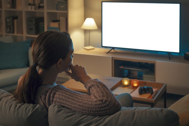 Woman watching TV and relaxing at home