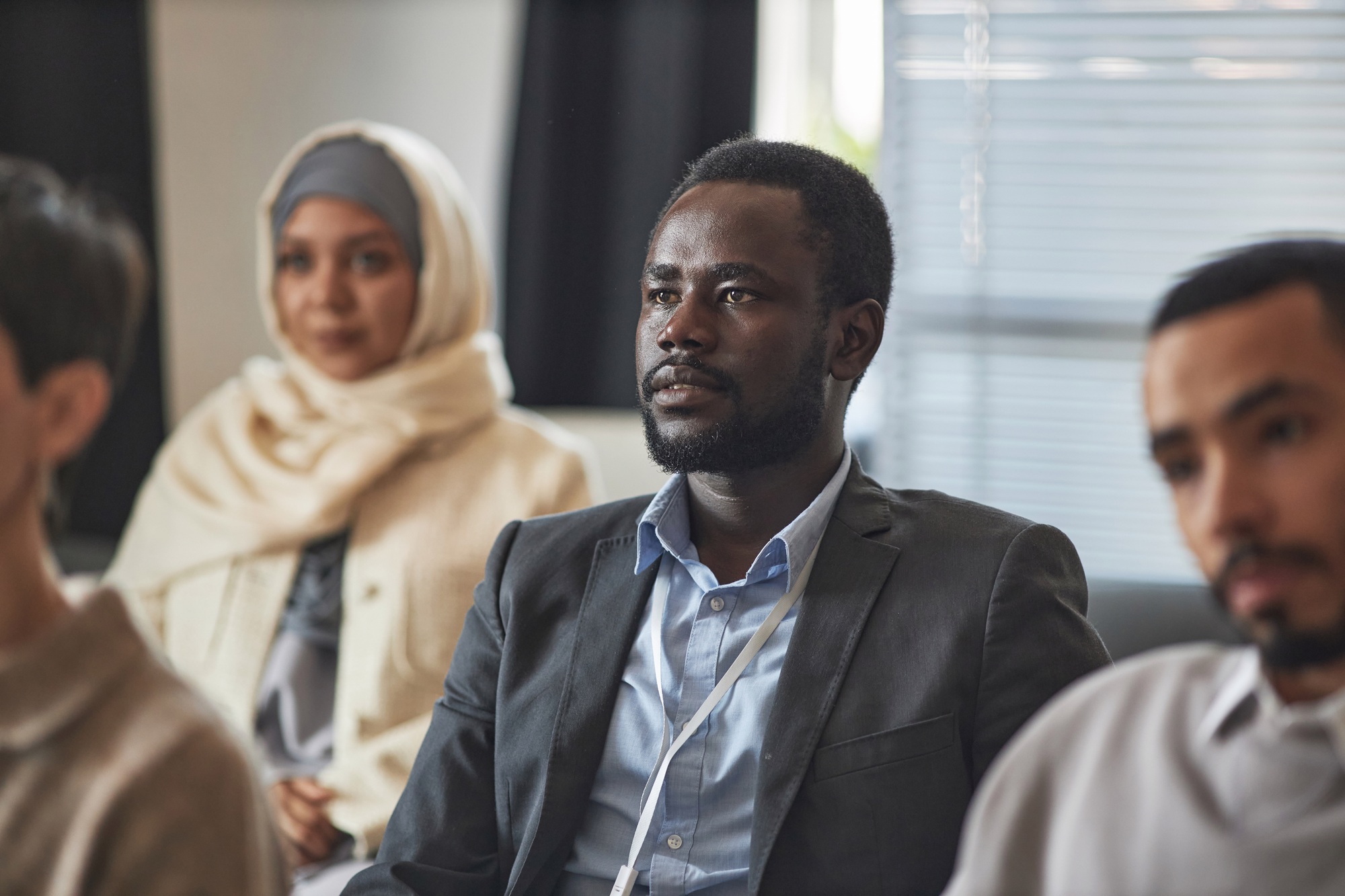 Young African American male employee in formalwear listening to speaker