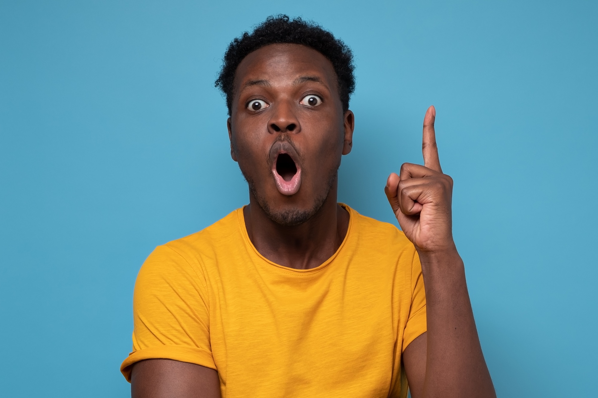 Young african man pointing with finger up having great idea for start up